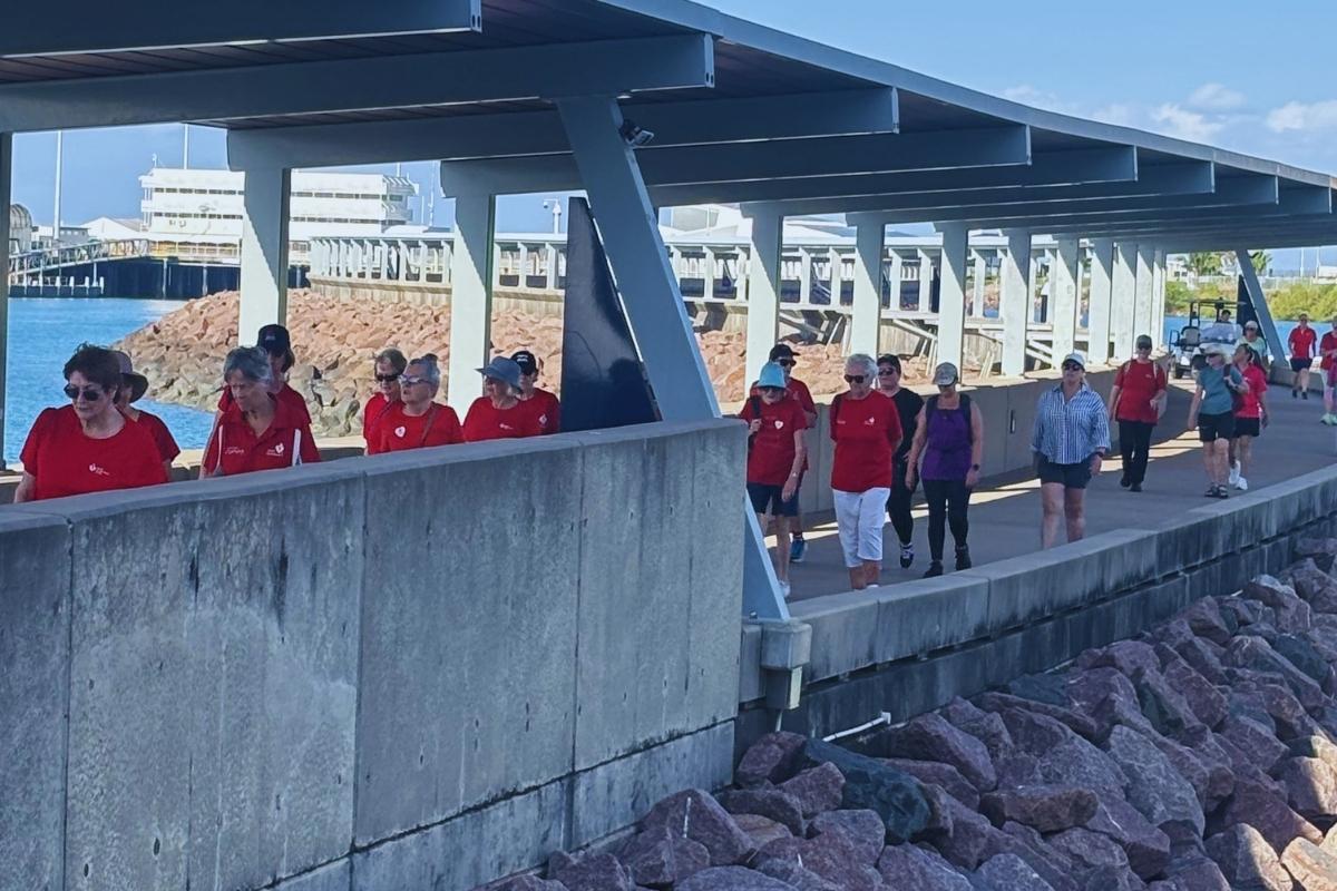 Group walking along path by the darwin water front