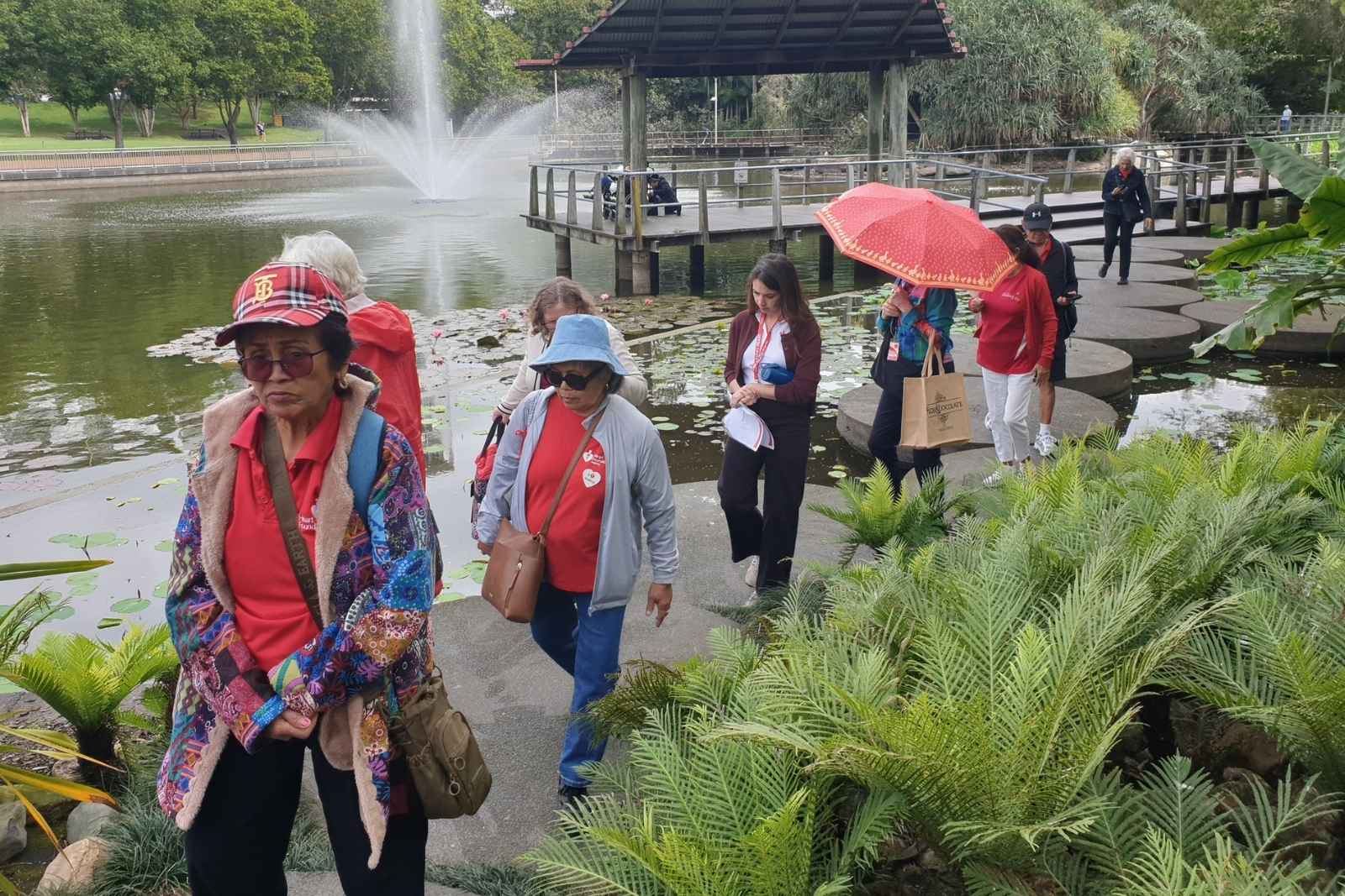Walking group walking by gardens pond