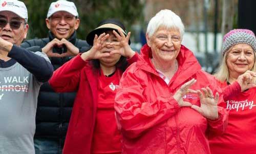 Group of Walkers in red making hand heart signs